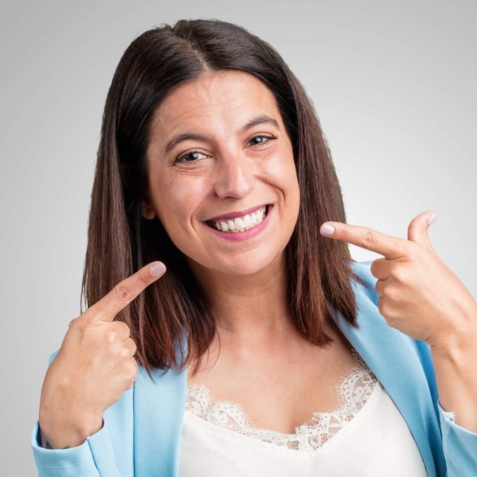 a girl showing her teeth after received teeth whitening treatment in Austin from River Rock Dental Austin office